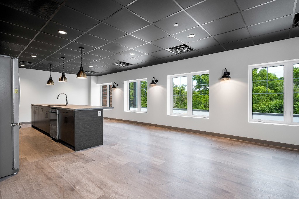 Party room lounge with kitchen island and windows at X Creemore Condos